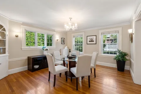 a view of a dining room with furniture a chandelier and wooden floor