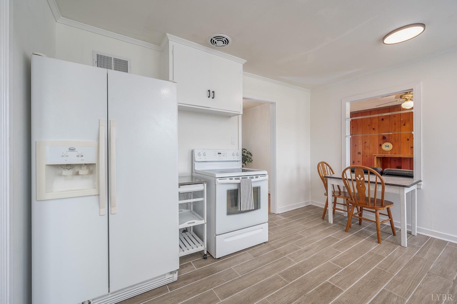 4794 Salem Road Spout Spring, VA 24593 - Photo 8 of 34 a kitchen with stainless steel appliances a refrigerator a stove a dining table and chairs with wooden floor