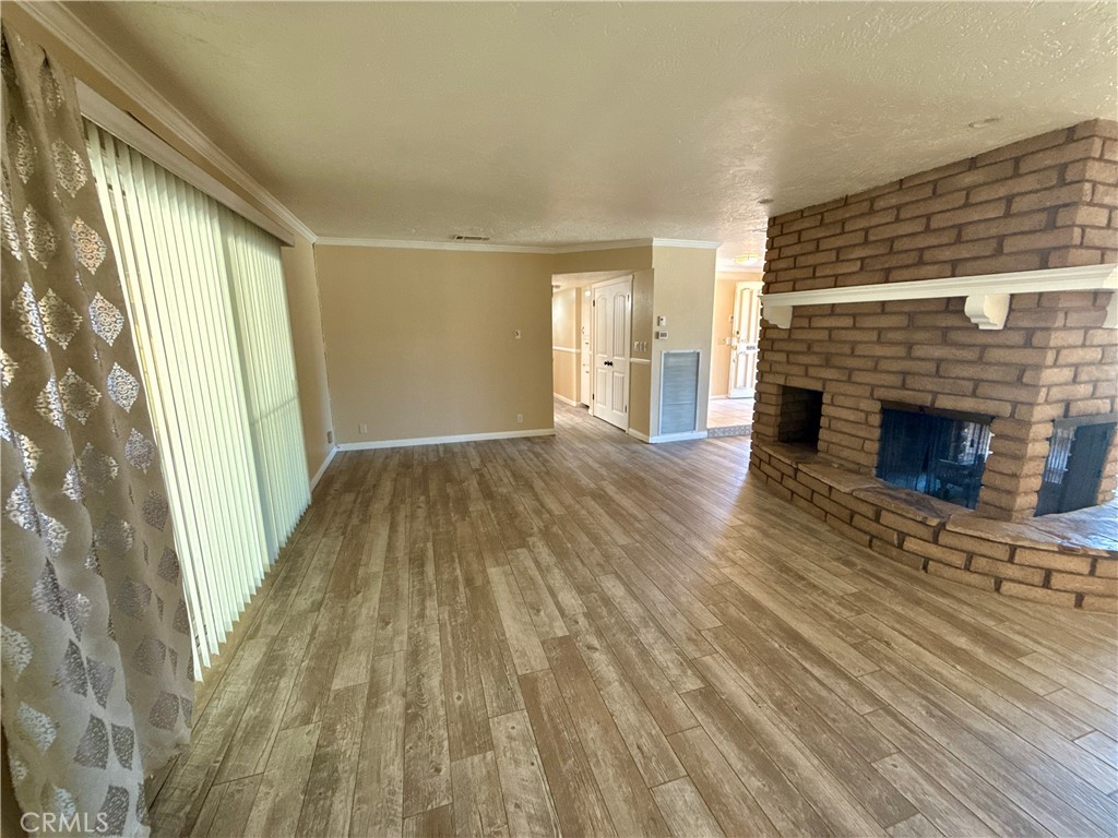 14705 Mandan Road Apple Valley, CA 92307 - Photo 6 of 20 a view of empty room with wooden floor and fireplace