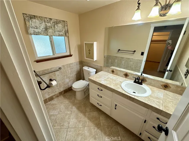 a bathroom with a granite countertop double vanity sink a mirror and a shower
