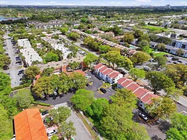 an aerial view of residential houses with outdoor space and trees