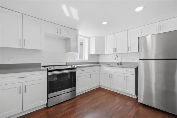 a kitchen with granite countertop white cabinets and white appliances