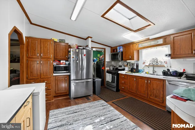 a kitchen with stainless steel appliances granite countertop a refrigerator stove and sink