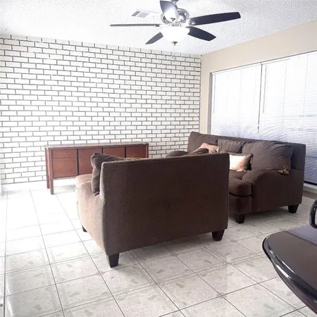 a living room with couches chairs and a large window with wooden floor