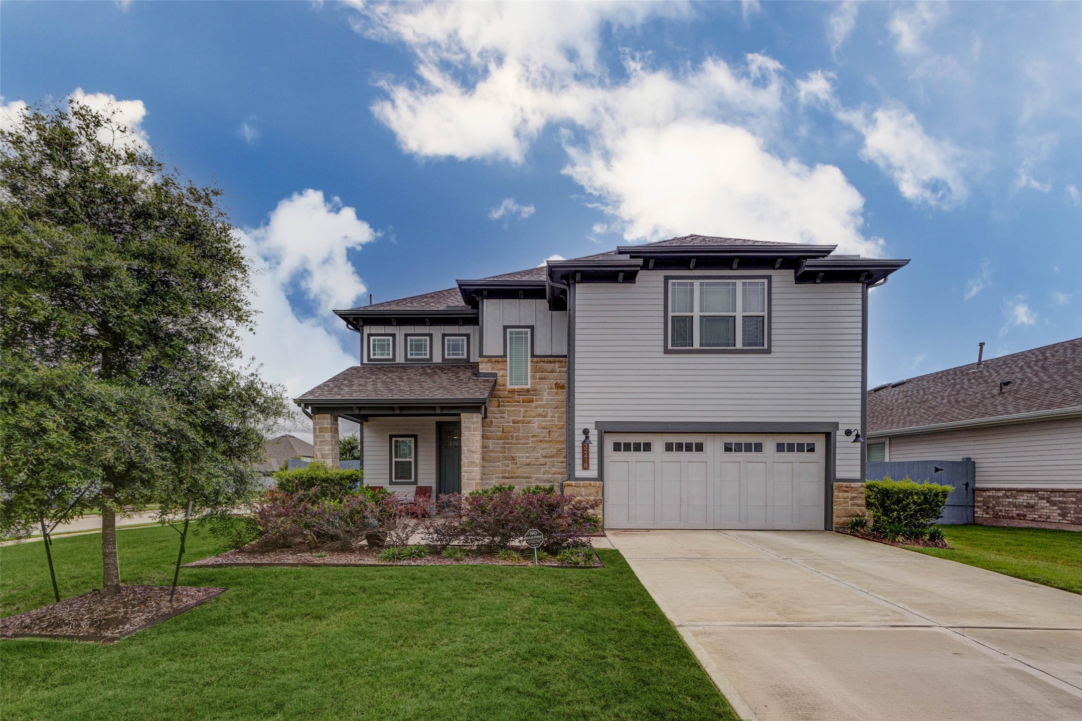 32418 Fly Fish Way Fulshear, TX 77441 - Photo 2 of 40 The extended double-wide driveway leads to an oversized two-car garage, featuring classic carriage-style doors with windows that add a charming architectural detail to the home's already impressive street presence.