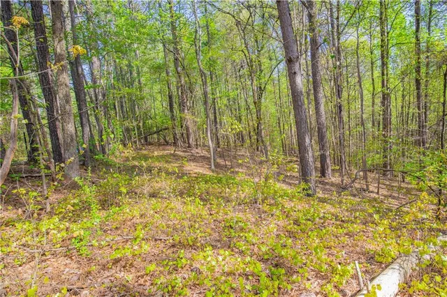 a view of swimming pool with lawn chairs and wooden fence