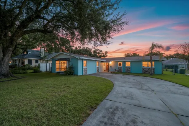 a front view of a house with a yard and trees