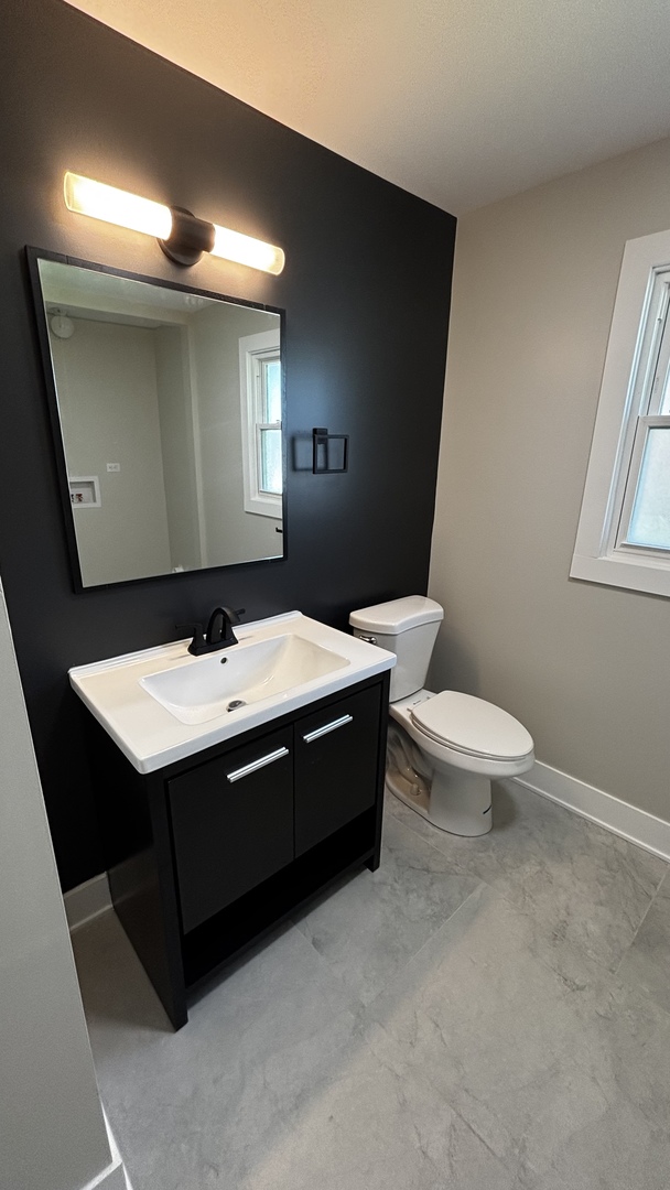 18314 Locust Street Lansing, IL 60438 - Photo 9 of 14 a bathroom with a sink mirror and toilet