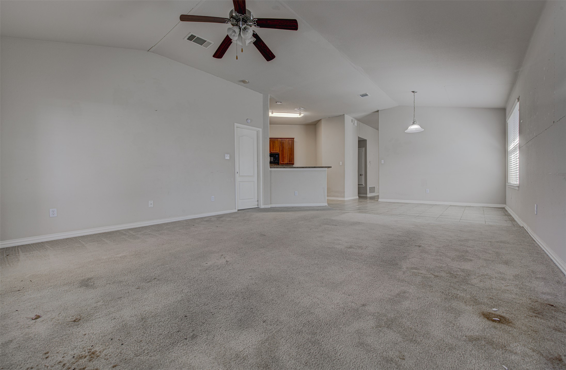 2090 Intrepid Drive Buda, TX 78610 - Photo 7 of 24 Unfurnished living room with light colored carpet and a ceiling fan