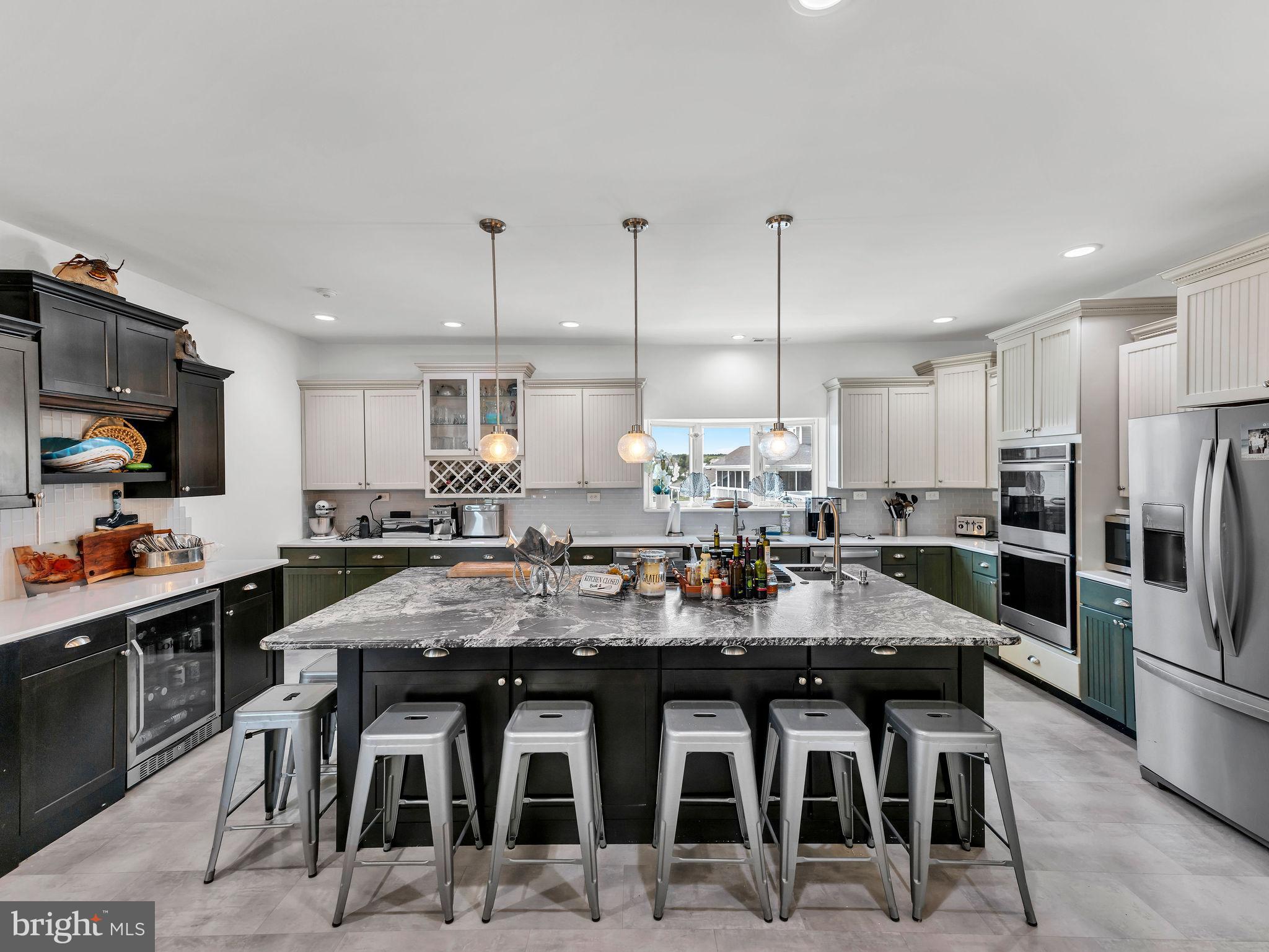 12608 Selsey Road Ocean City, MD 21842 - Photo 16 of 66 a kitchen with stainless steel appliances kitchen island granite countertop a stove a sink a refrigerator and chairs