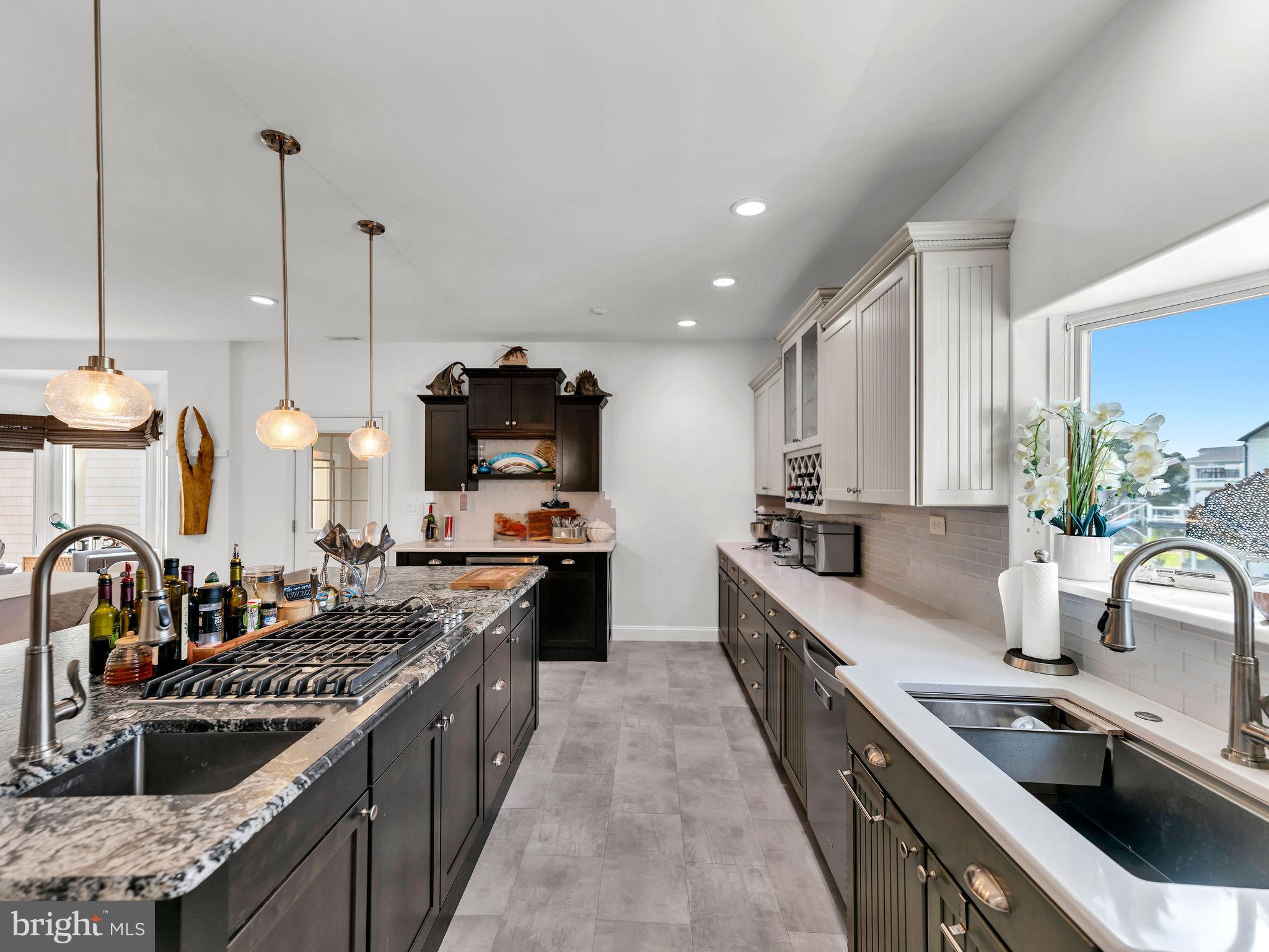 12608 Selsey Road Ocean City, MD 21842 - Photo 22 of 66 a kitchen with kitchen island granite countertop a sink a counter top space stove and cabinets