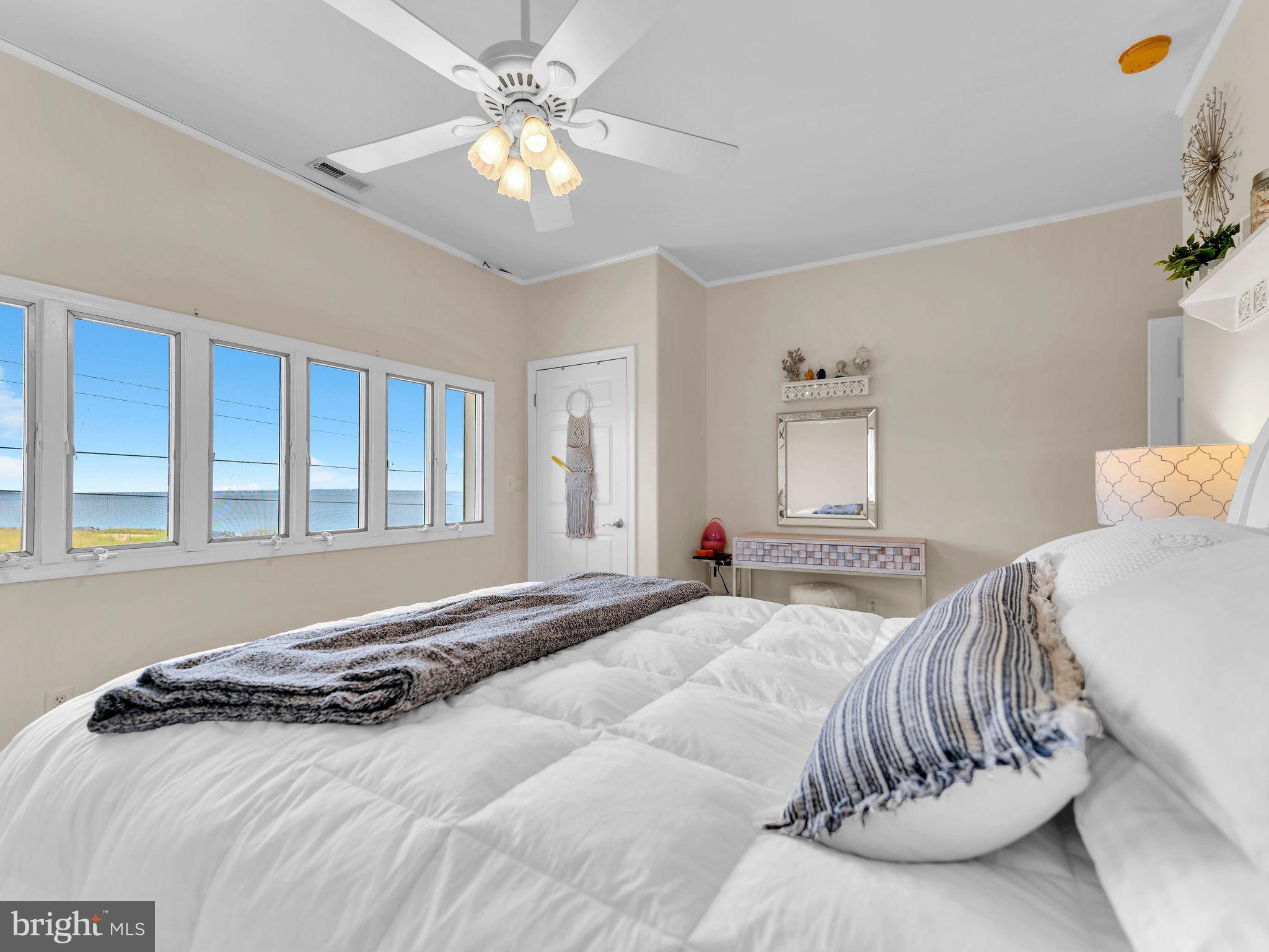 12608 Selsey Road Ocean City, MD 21842 - Photo 36 of 66 a bedroom with a bed and a chandelier