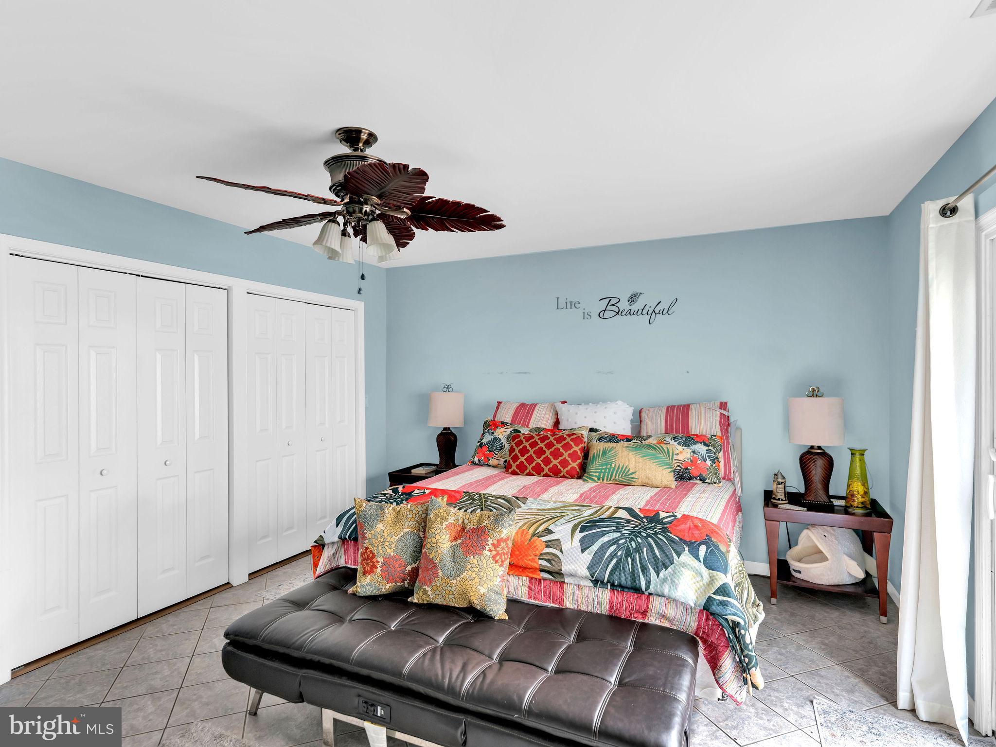 12608 Selsey Road Ocean City, MD 21842 - Photo 39 of 66 a bedroom with a bed and a chandelier