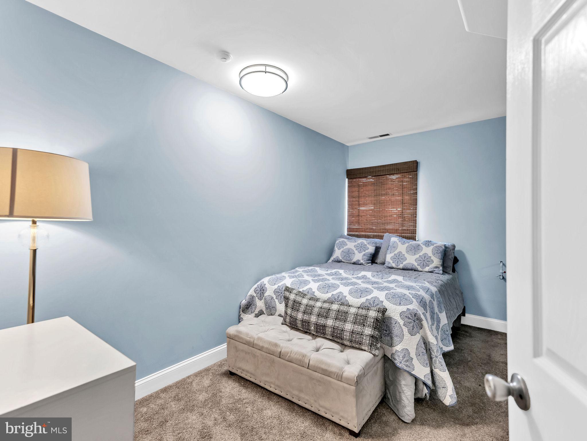 12608 Selsey Road Ocean City, MD 21842 - Photo 41 of 66 a bedroom with a bed and a lamp