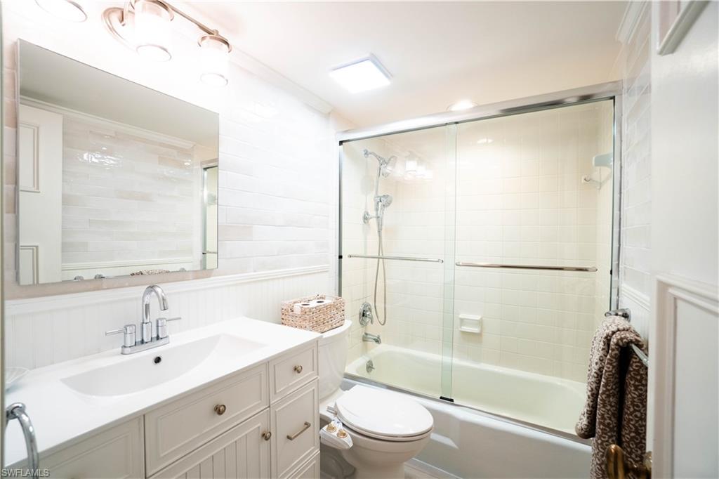 388 4th Avenue South, Unit 388 Naples, FL 34102 - Photo 7 of 15 a bathroom with a bathtub shower sink vanity mirror and toilet