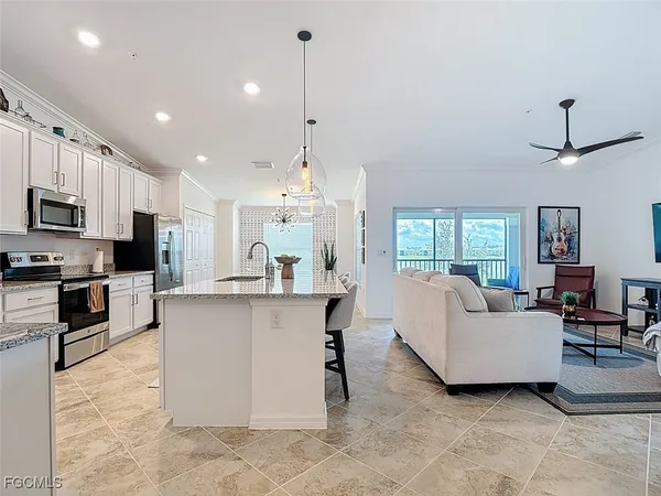 a kitchen with kitchen island granite countertop a sink center island stainless steel appliances and cabinets