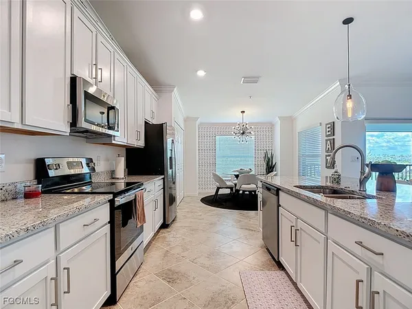 a kitchen with granite countertop white cabinets and stainless steel appliances