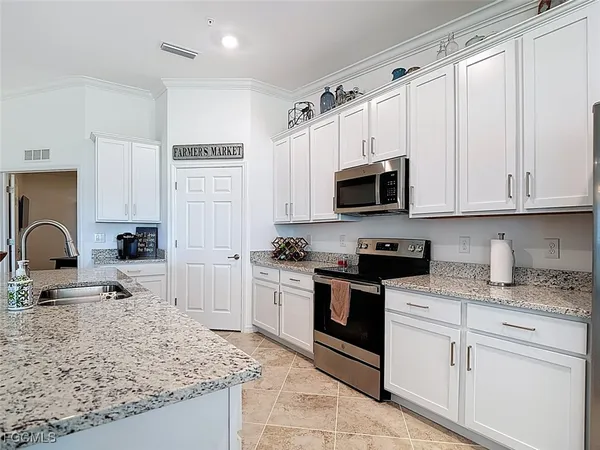 a kitchen with a sink and living room view