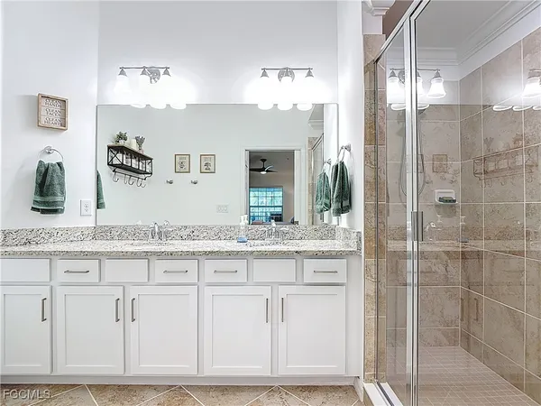 a bathroom with a granite countertop toilet sink and mirror