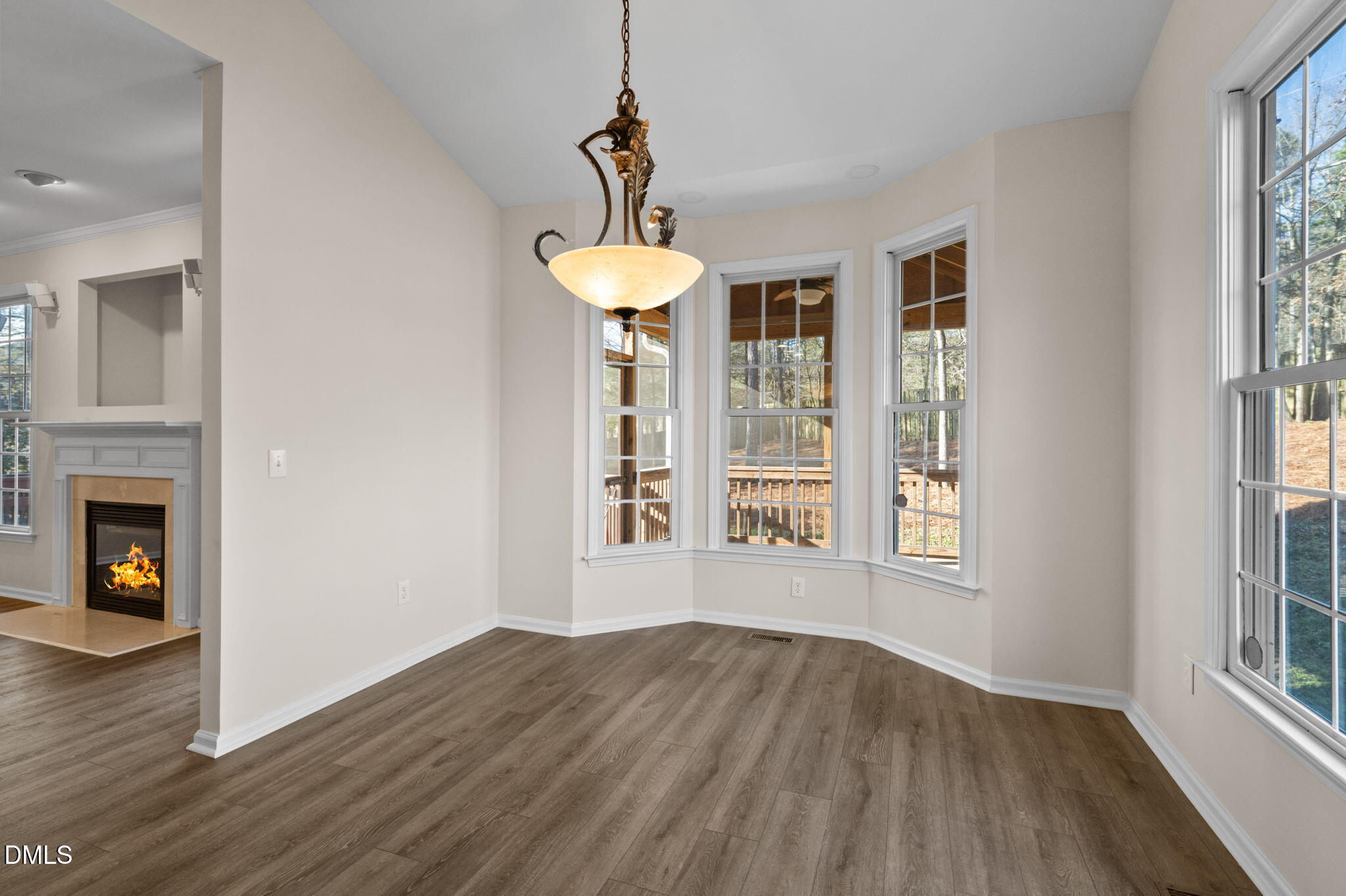 707 Martry Road Durham, NC 27713 - Photo 12 of 61 a view of an empty room with wooden floor fireplace and windows