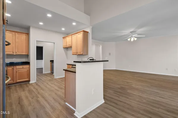 a kitchen with stainless steel appliances granite countertop wooden cabinets a stove a sink and dishwasher with wooden floor