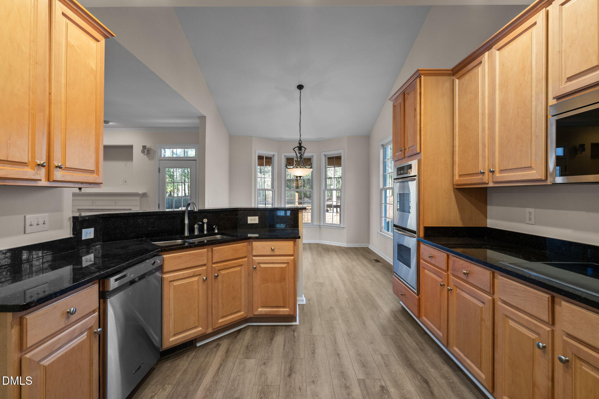 707 Martry Road Durham, NC 27713 - Photo 15 of 61 a kitchen with stainless steel appliances granite countertop wooden cabinets a stove a sink and dishwasher with wooden floor