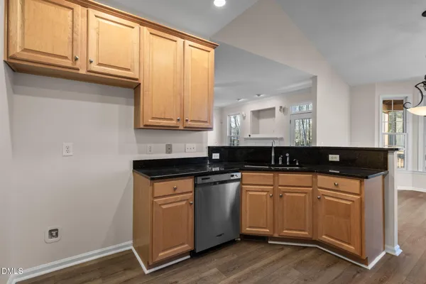 a kitchen with granite countertop white cabinets and black appliances