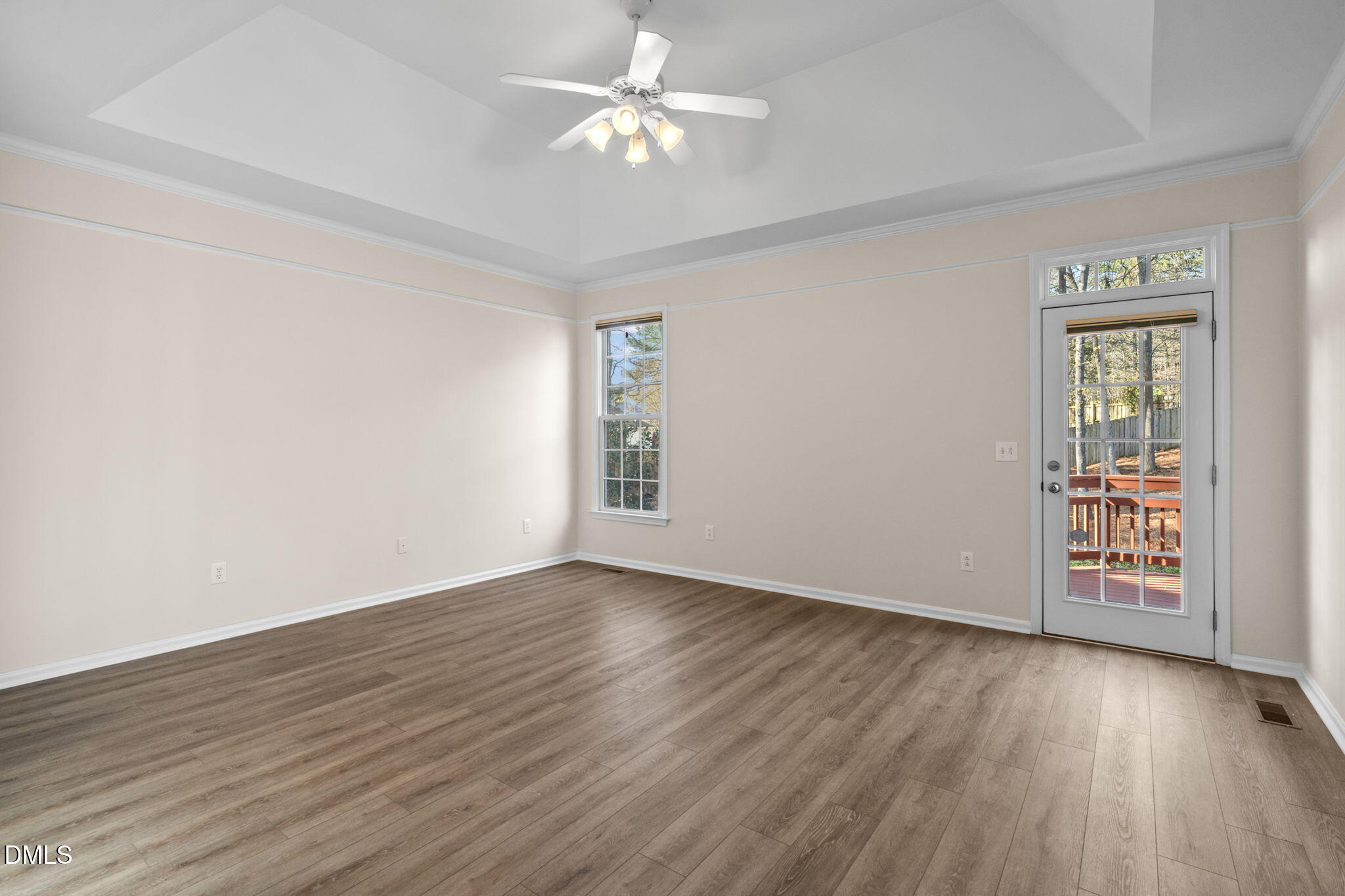 707 Martry Road Durham, NC 27713 - Photo 20 of 61 an empty room with wooden floor chandelier fan and windows