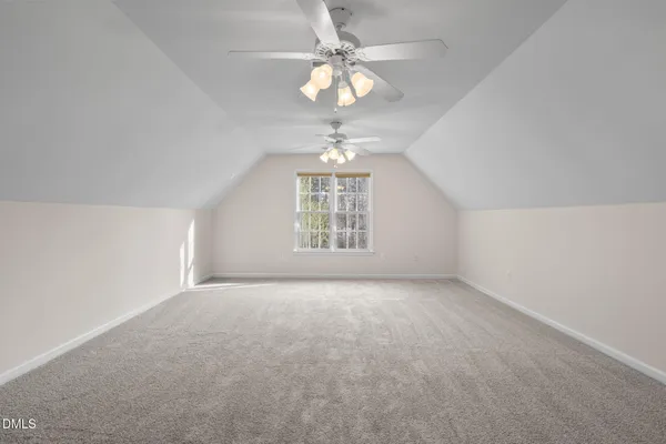 a view of an empty room with a chandelier fan