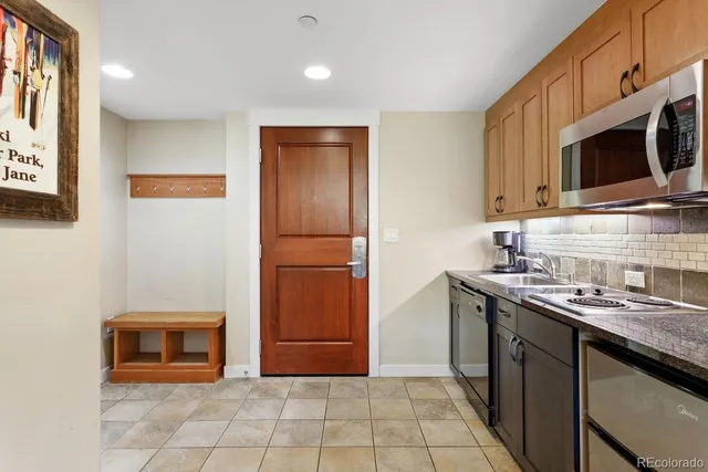 a kitchen with stainless steel appliances granite countertop a refrigerator a stove top oven and sink