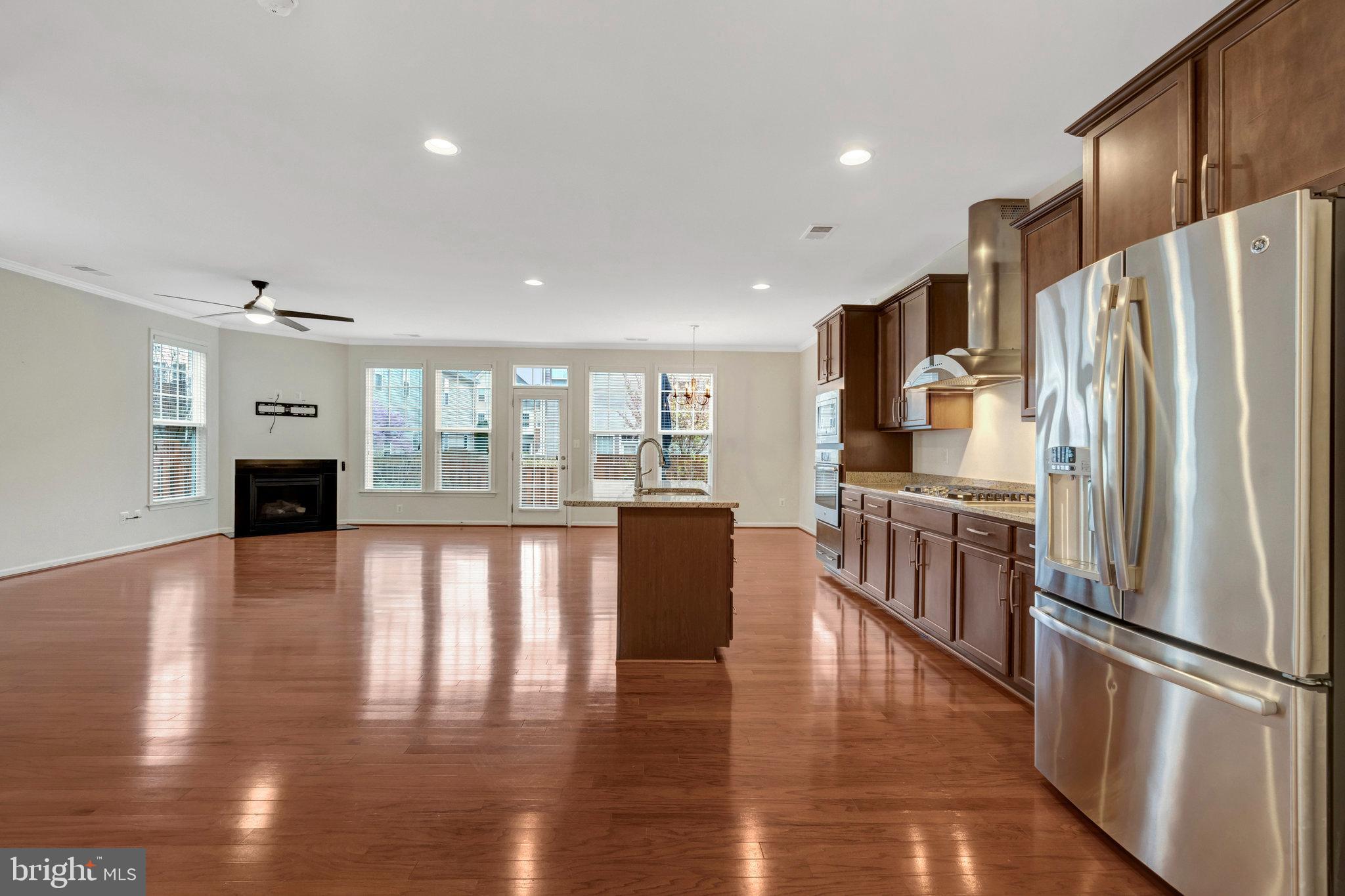 41841 Diabase Square Aldie, VA 20105 - Photo 5 of 45 a kitchen with stainless steel appliances granite countertop a refrigerator microwave and wooden floor