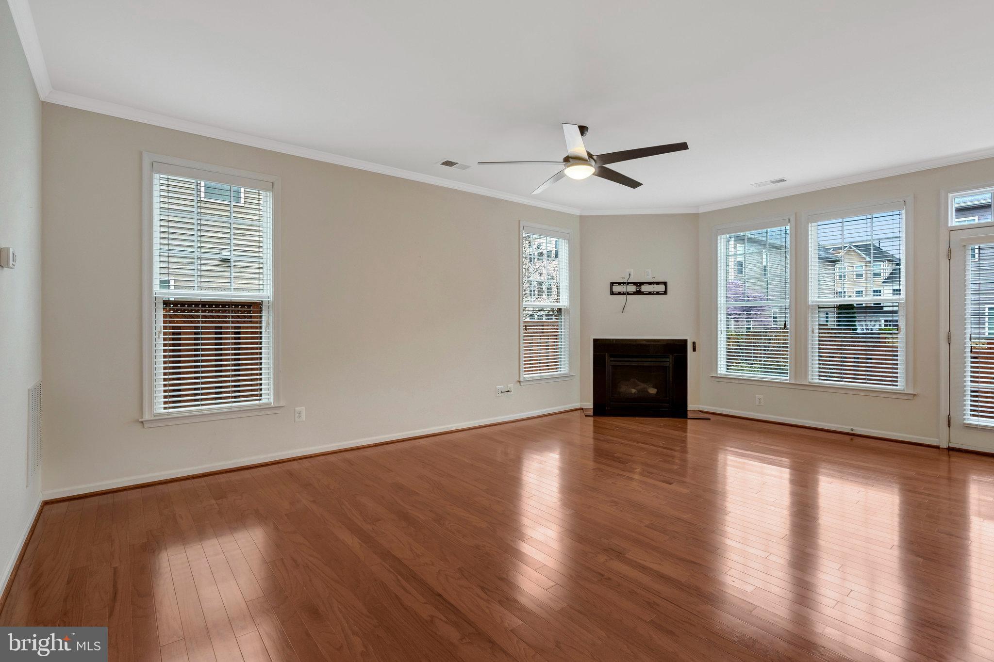 41841 Diabase Square Aldie, VA 20105 - Photo 6 of 45 a view of a livingroom with wooden floor a ceiling fan and windows