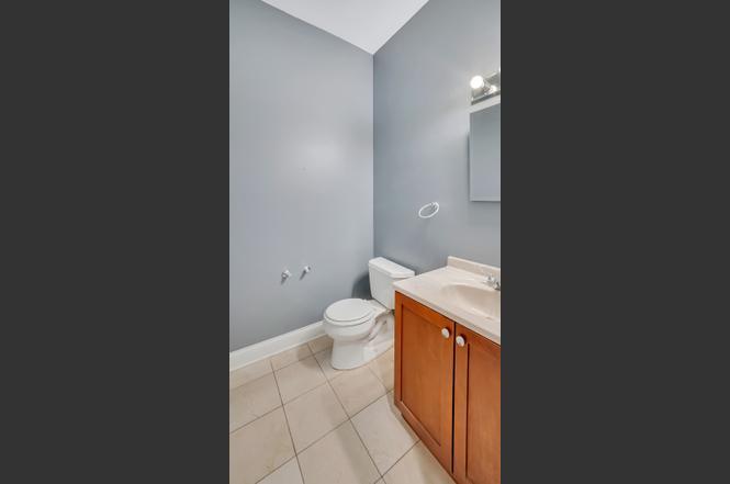 2417 West Fillmore Street, Unit 1 Chicago, IL 60612 - Photo 11 of 16 a bathroom with a granite countertop toilet and a sink