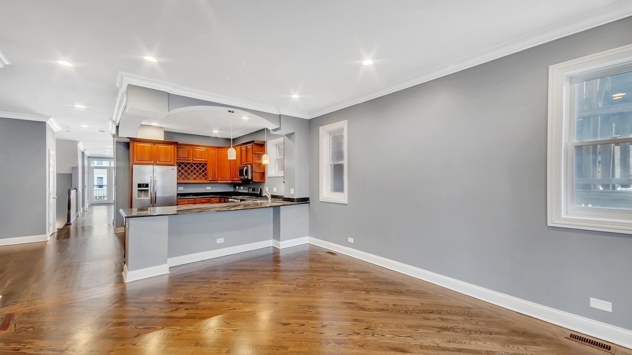 2417 West Fillmore Street, Unit 1 Chicago, IL 60612 - Photo 7 of 16 a view of a room with kitchen island stainless steel appliances wooden floor and window