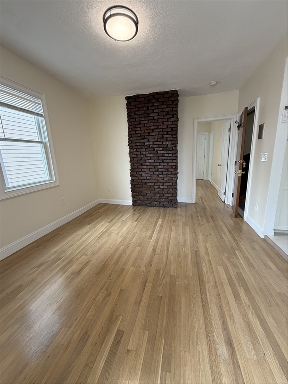 26 Brooks Street, Unit 2 Boston, MA 02128 - Photo 5 of 12 an empty room with wooden floor and windows