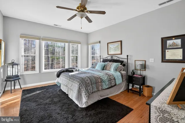a bedroom with a bed a bookshelf and a large window