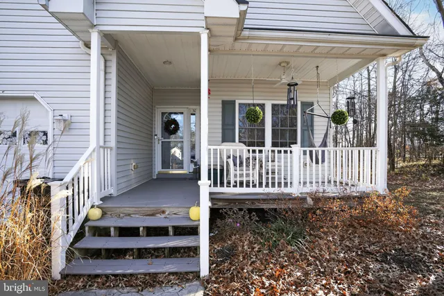 a view of a house with wooden deck and a yard
