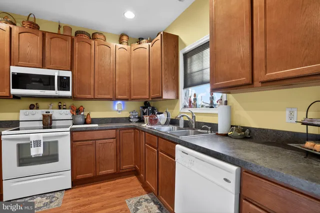 a kitchen with stainless steel appliances granite countertop a sink a stove and cabinets