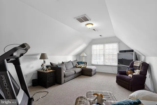 a living room with furniture gym equipment and a window