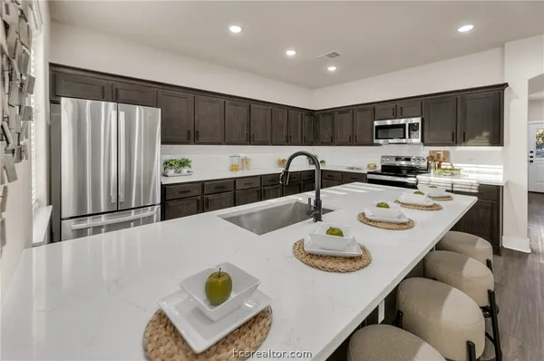 a kitchen with a sink a stove and chairs