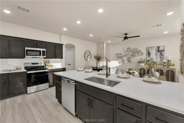 a kitchen with a sink stainless steel appliances and cabinets