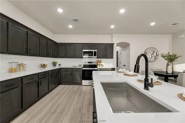 a kitchen with a sink stainless steel appliances and cabinets