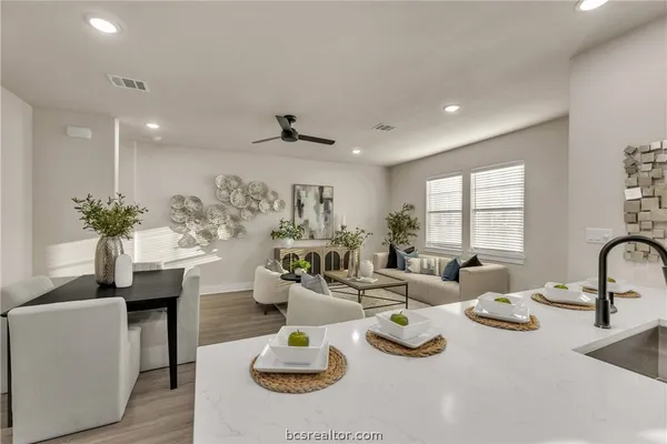 a living room with furniture kitchen and a large window