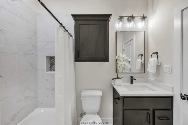 a bathroom with a sink a toilet and shower