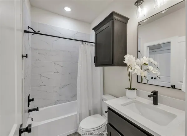 a bathroom with a sink a toilet and shower