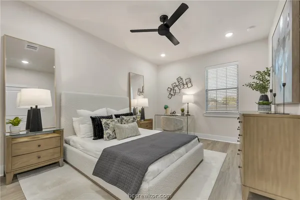 a bedroom with a large bed and a chandelier