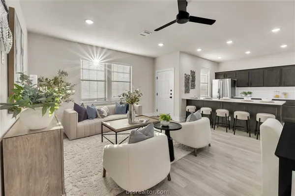 a living room with furniture and a kitchen view