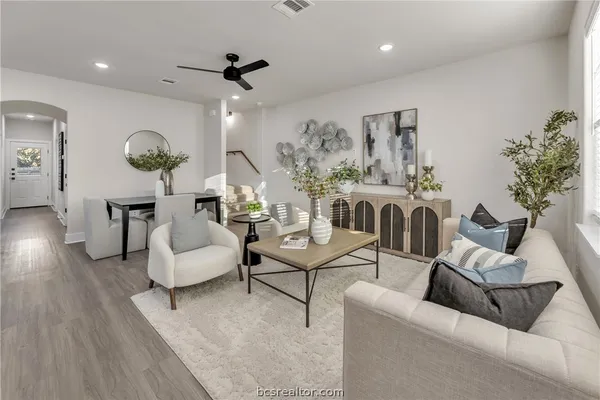 a living room with furniture and a large mirror with wooden floor