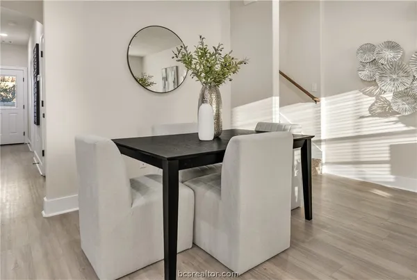 a vase of flowers sitting on a table with wooden floor