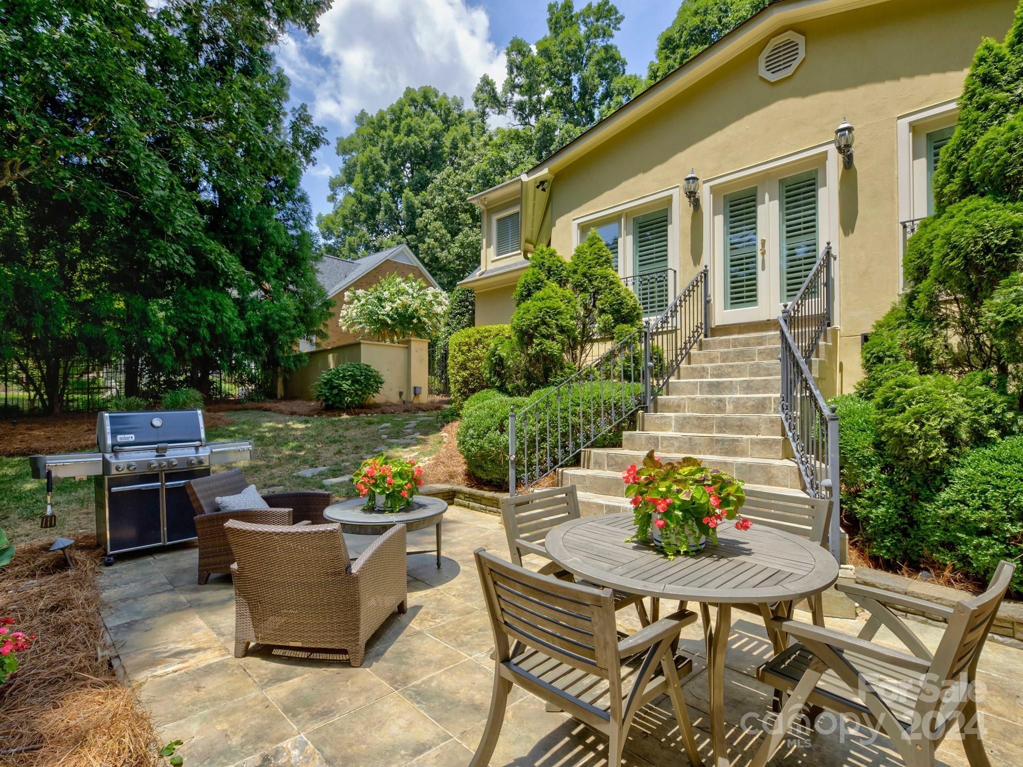 4440 Canoebrook Road Charlotte, NC 28210 - Photo 42 of 47 a view of a patio with table and chairs potted plants and a house